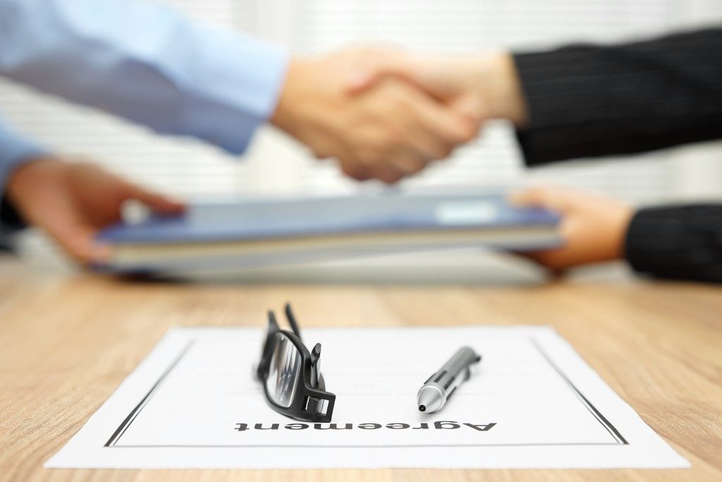 Woman shaking hands after signing an agreement