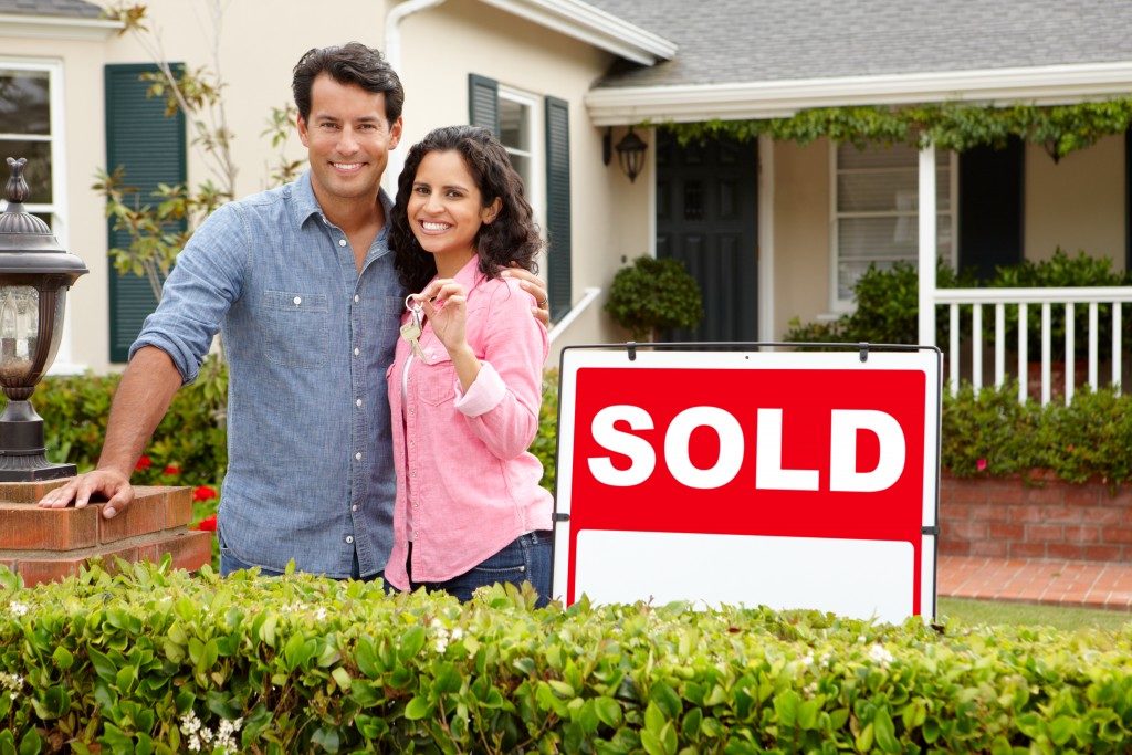 Couple standing outside their new home