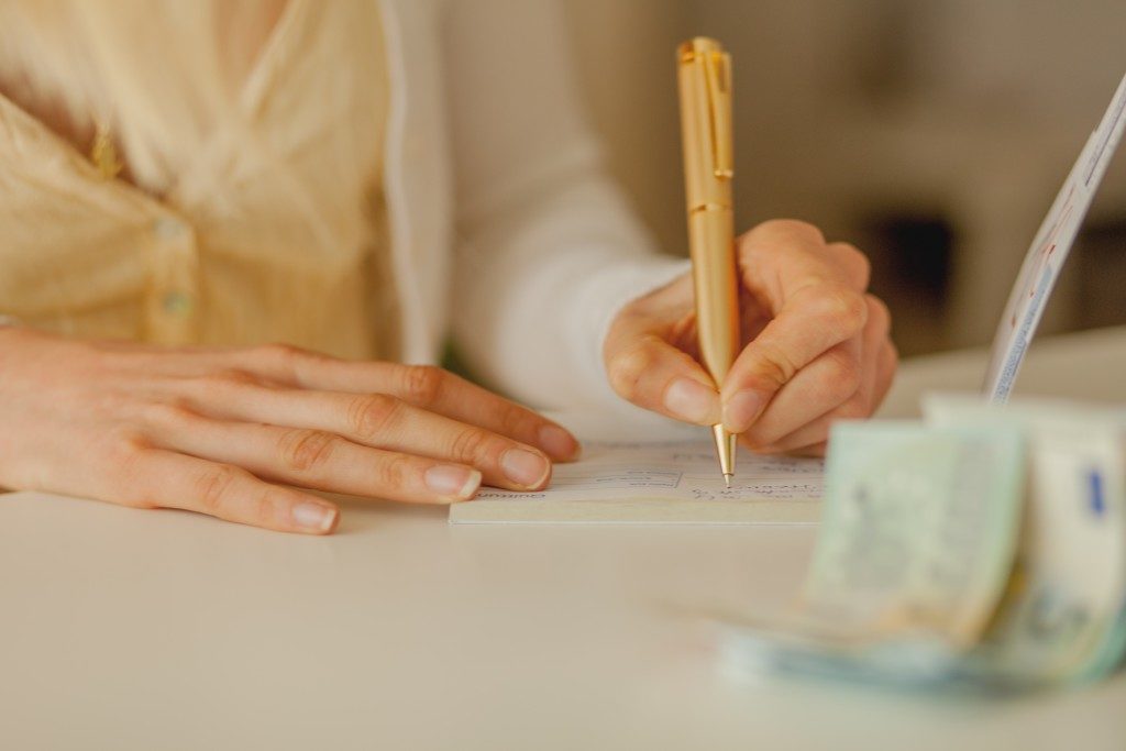 hand of a woman signing a cheque