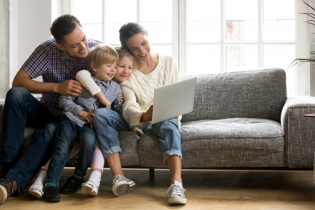 A couple playing with their kids using a laptop