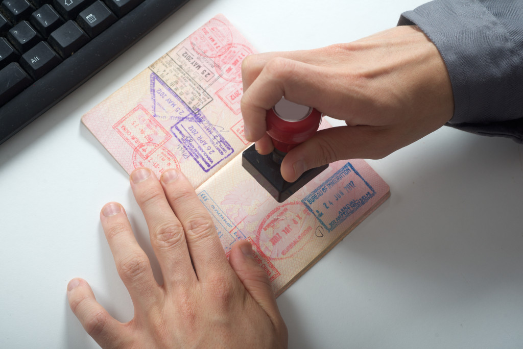 An Officer Holding a Passport Giving Visa Approval Stamp